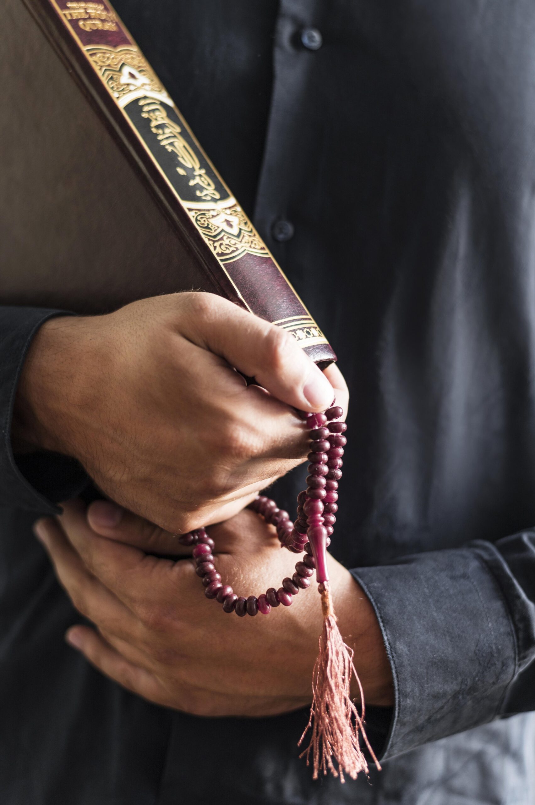 person-holding-rosary-religious-book